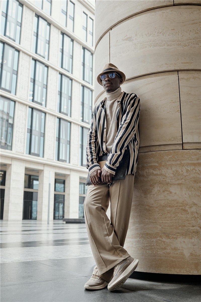 Model wearing a striped shirt and relaxed tailored trousers